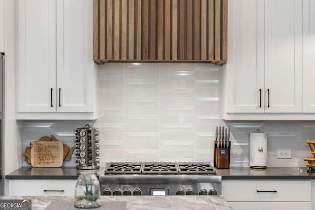 kitchen featuring tasteful backsplash, white cabinetry, and dark countertops