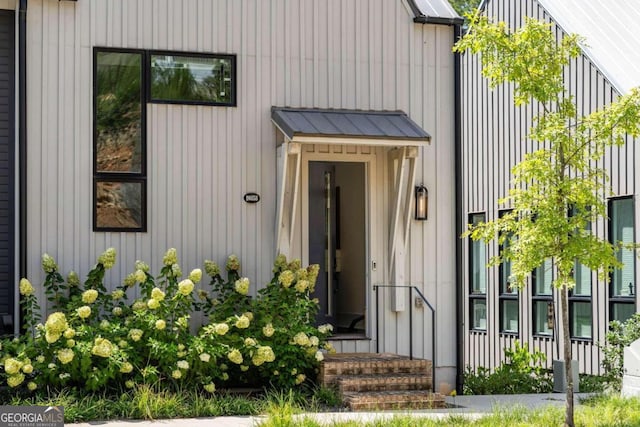 doorway to property with board and batten siding, metal roof, and a standing seam roof