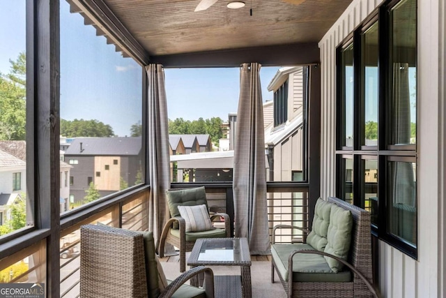 sunroom / solarium with wood ceiling and a ceiling fan