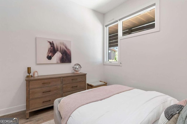 bedroom with light wood-type flooring and baseboards