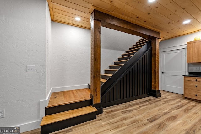 staircase featuring wood ceiling and hardwood / wood-style flooring