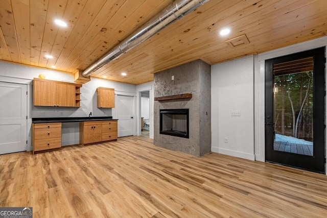 kitchen featuring a fireplace, wood ceiling, and light hardwood / wood-style floors