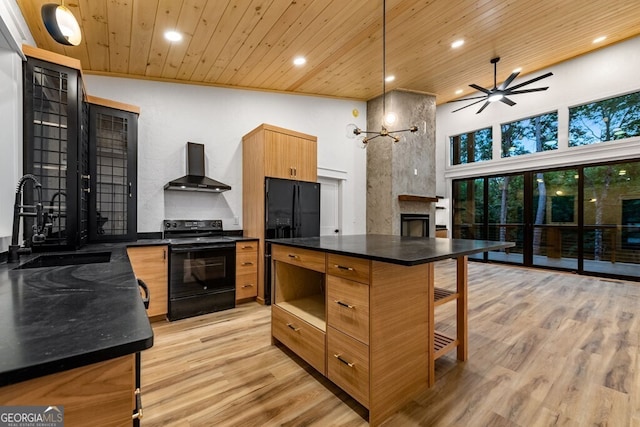 kitchen with high vaulted ceiling, wall chimney exhaust hood, black appliances, and light hardwood / wood-style floors