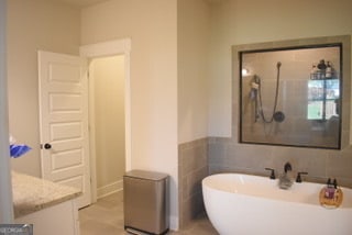 bathroom featuring tile patterned flooring, vanity, and independent shower and bath