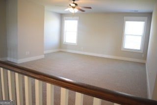 carpeted spare room featuring ceiling fan