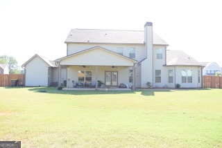 back of house with a yard and a patio