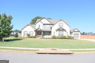 view of front of property featuring a front lawn and a garage