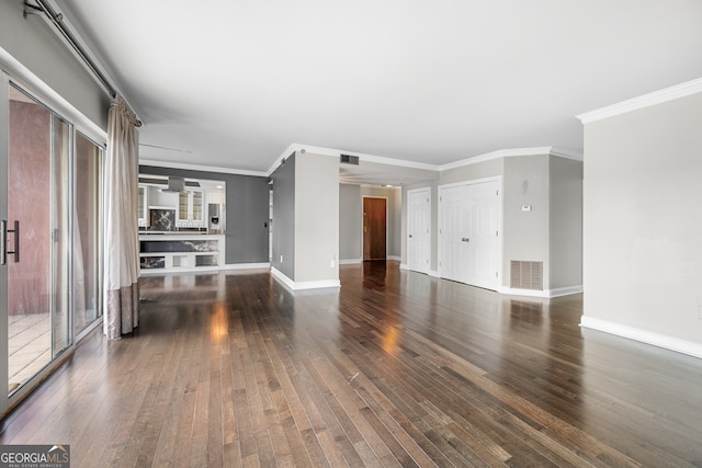 unfurnished living room featuring crown molding and dark hardwood / wood-style floors