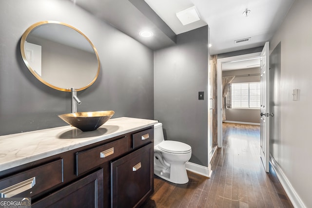 bathroom with vanity, toilet, and hardwood / wood-style flooring