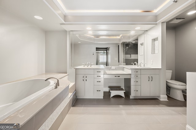 bathroom with vanity, tiled bath, a tray ceiling, tile patterned flooring, and toilet