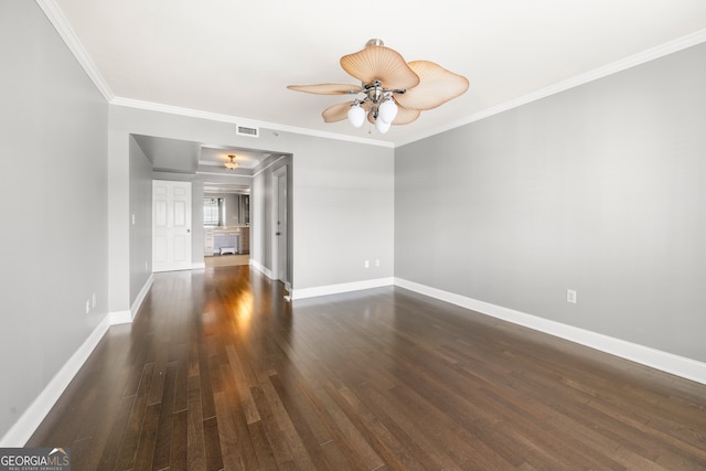 empty room with crown molding, ceiling fan, and dark hardwood / wood-style flooring