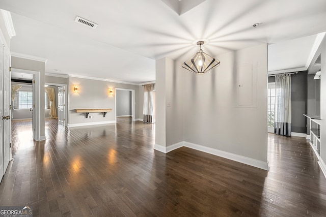 unfurnished room with dark wood-type flooring, ornamental molding, and a notable chandelier