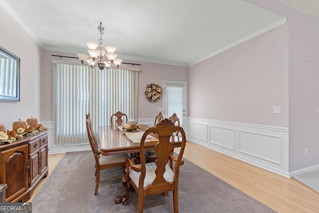 dining area featuring a notable chandelier, wood-type flooring, and crown molding