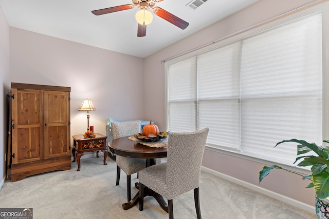 carpeted dining space featuring ceiling fan