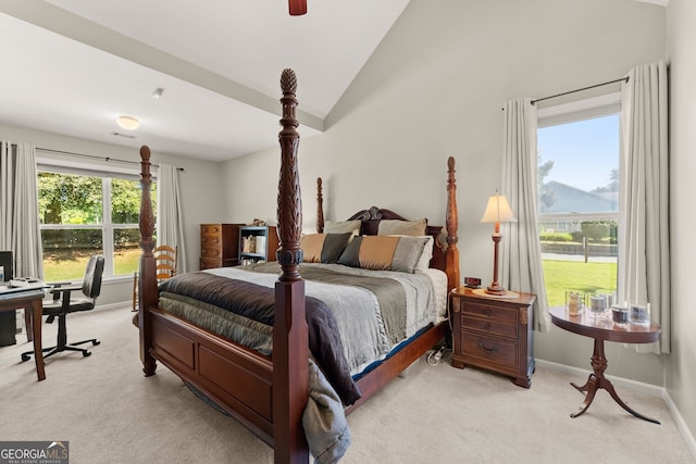 bedroom with lofted ceiling, multiple windows, and light colored carpet