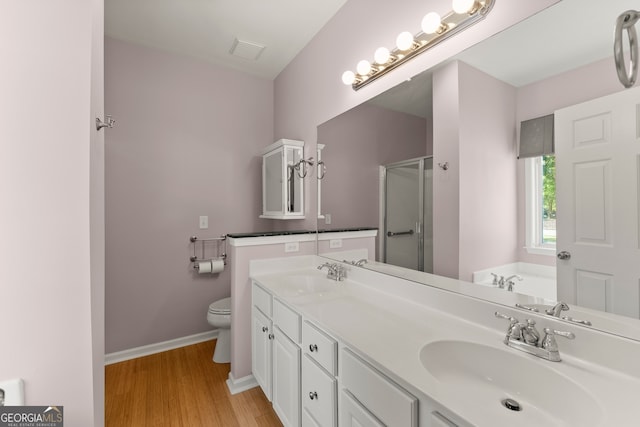 full bathroom with wood-type flooring, separate shower and tub, vanity, and toilet