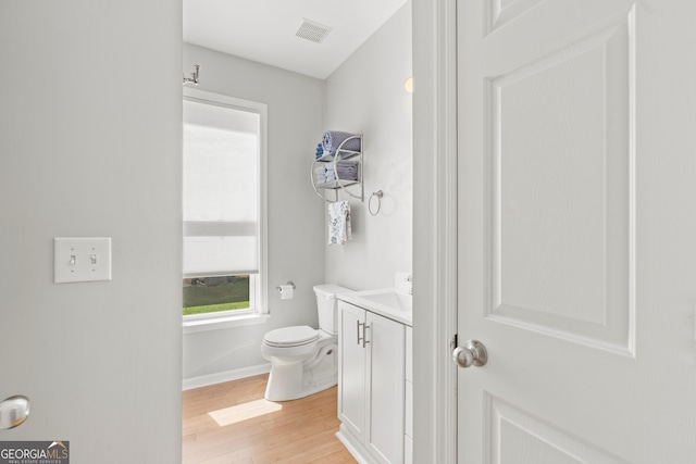 bathroom with hardwood / wood-style floors, vanity, and toilet