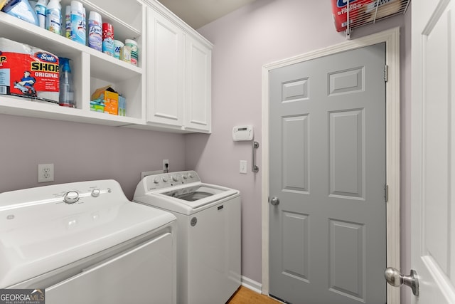 laundry room with washer and clothes dryer, cabinets, and light wood-type flooring