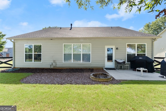 rear view of house with a yard, a patio, and an outdoor fire pit