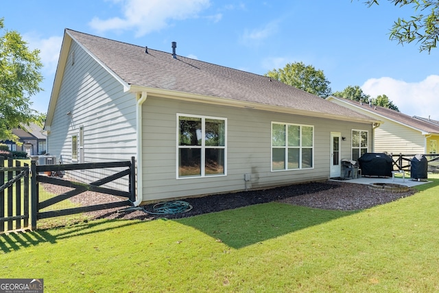 rear view of house featuring a lawn and a patio