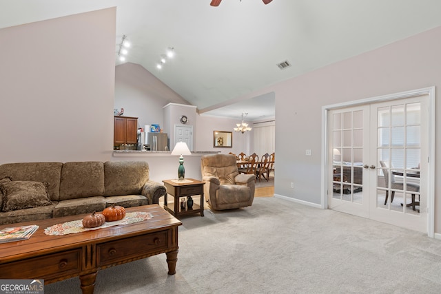 carpeted living room with french doors, ceiling fan with notable chandelier, and lofted ceiling