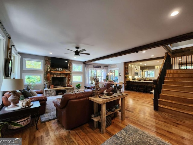 living room featuring plenty of natural light, hardwood / wood-style flooring, and a stone fireplace