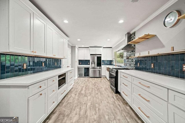 kitchen featuring light wood-type flooring, crown molding, white cabinetry, backsplash, and appliances with stainless steel finishes