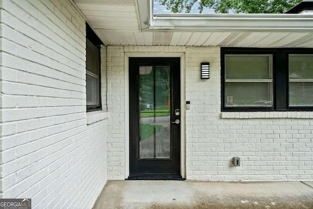 entrance to property featuring brick siding