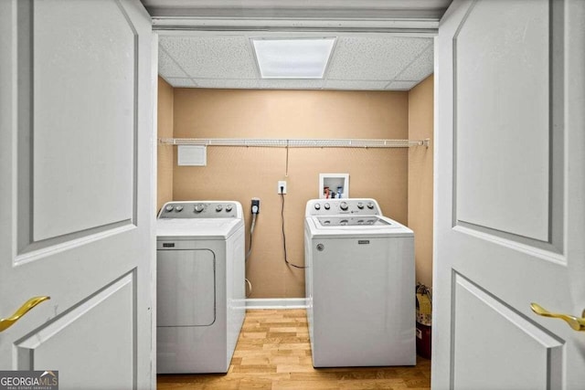 clothes washing area with light hardwood / wood-style flooring and separate washer and dryer