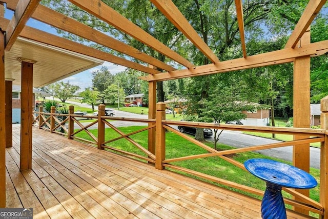 deck with a pergola and a lawn