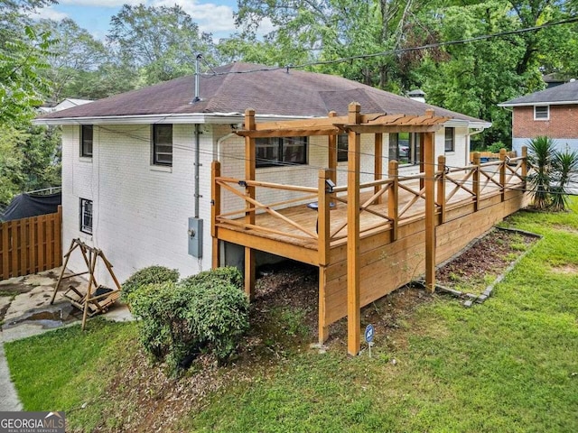 rear view of house with a yard and a wooden deck