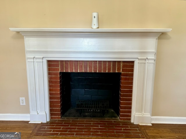 details with a brick fireplace and hardwood / wood-style floors