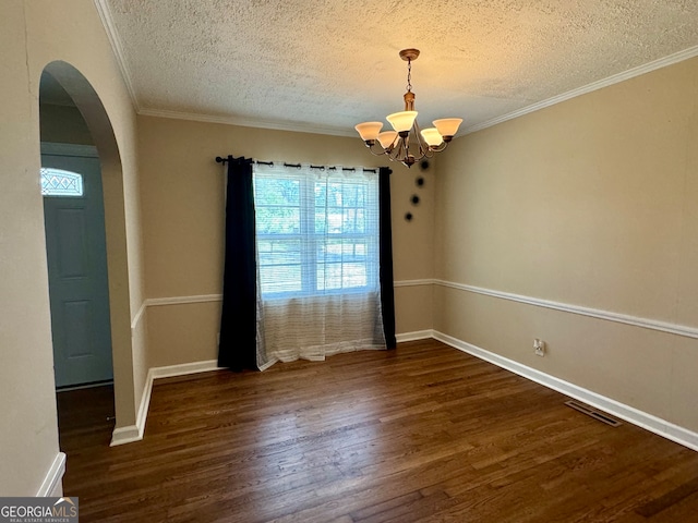 spare room with ornamental molding, dark hardwood / wood-style flooring, a chandelier, and a textured ceiling