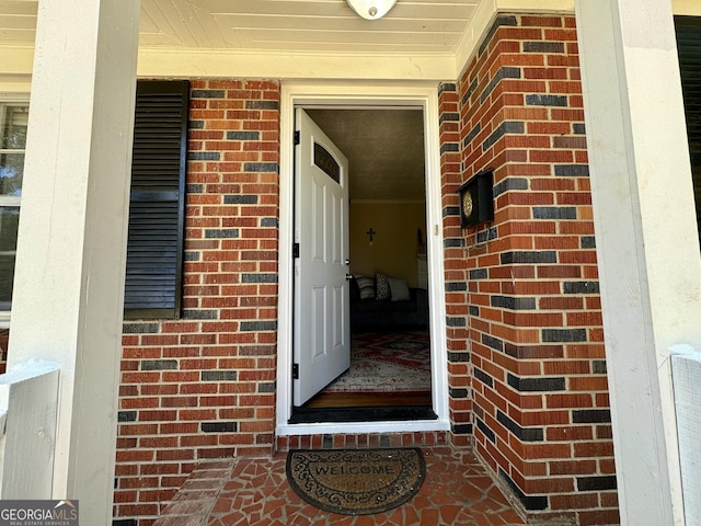 doorway to property featuring brick siding