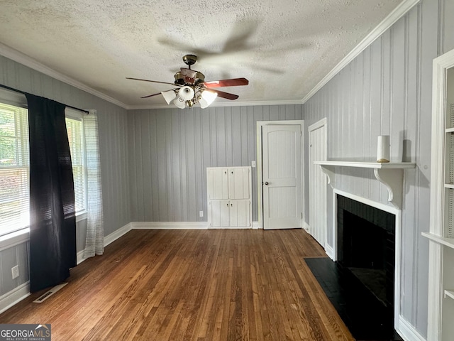 unfurnished living room featuring a textured ceiling, ceiling fan, ornamental molding, and hardwood / wood-style flooring