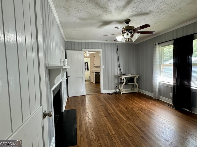 unfurnished living room with ceiling fan, dark hardwood / wood-style floors, crown molding, and a textured ceiling