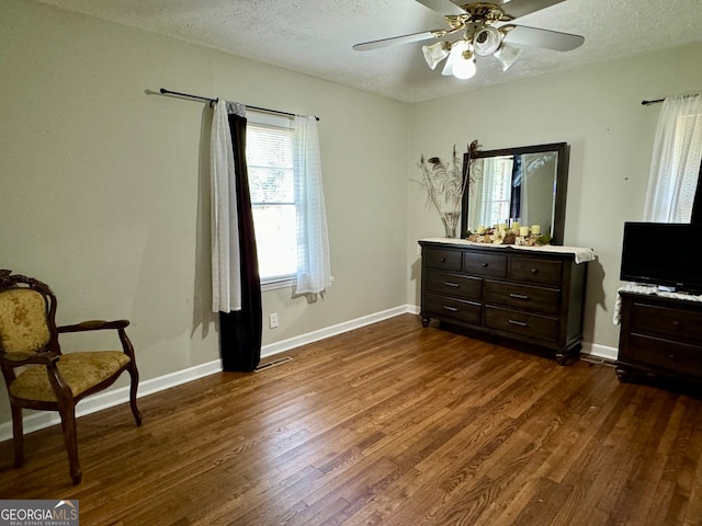 bedroom featuring ceiling fan, dark hardwood / wood-style floors, and a textured ceiling