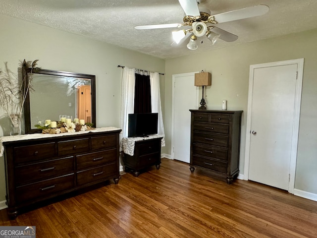 bedroom with ceiling fan, hardwood / wood-style flooring, and a textured ceiling