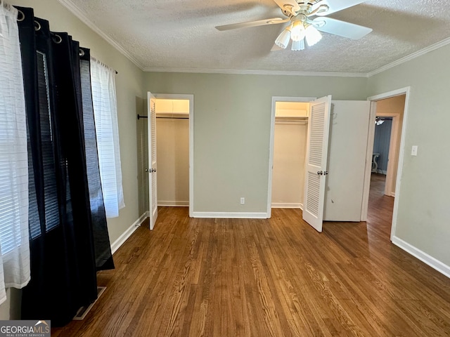 unfurnished bedroom with wood-type flooring, crown molding, a textured ceiling, and ceiling fan