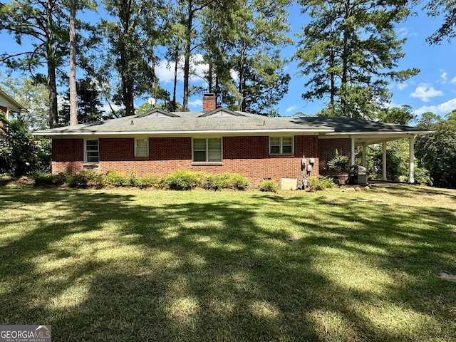 rear view of property featuring a lawn