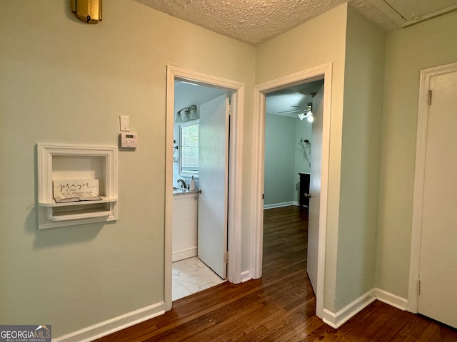 hall with a textured ceiling and hardwood / wood-style flooring