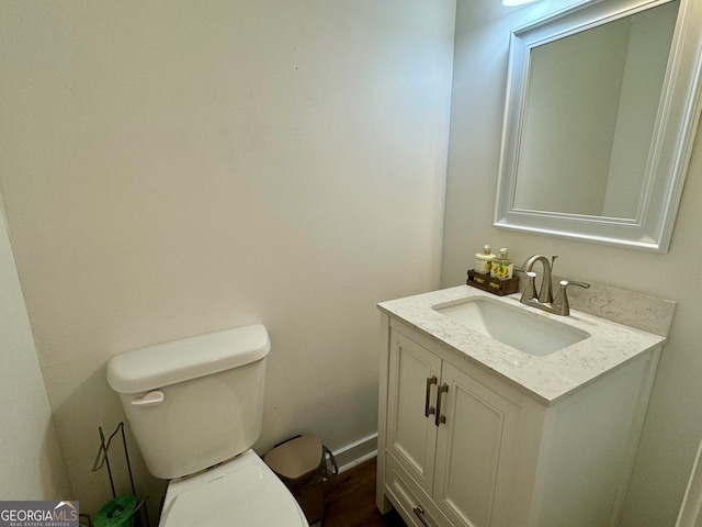 bathroom featuring vanity, toilet, and hardwood / wood-style floors