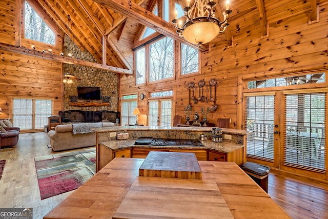 kitchen featuring hardwood / wood-style floors, wood ceiling, wooden walls, and black stovetop