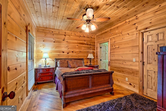 bedroom featuring wood walls, light hardwood / wood-style floors, and wooden ceiling