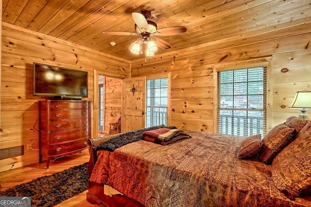 bedroom with hardwood / wood-style floors, wood ceiling, and wooden walls