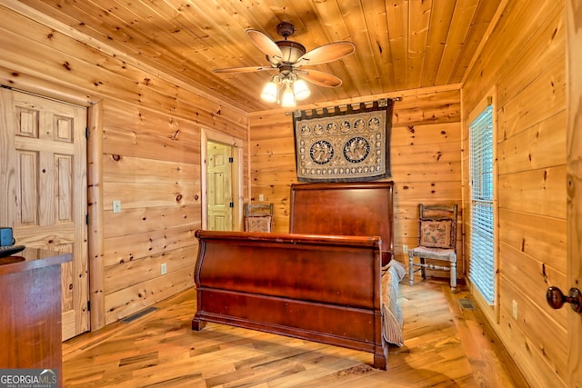 bedroom featuring wood walls, wood ceiling, and light hardwood / wood-style flooring