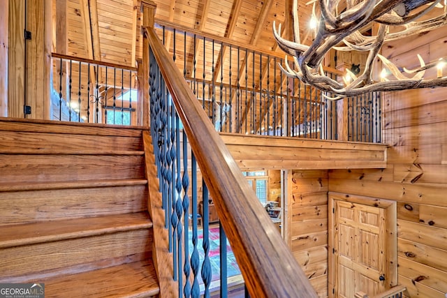 stairs featuring wooden walls and wooden ceiling