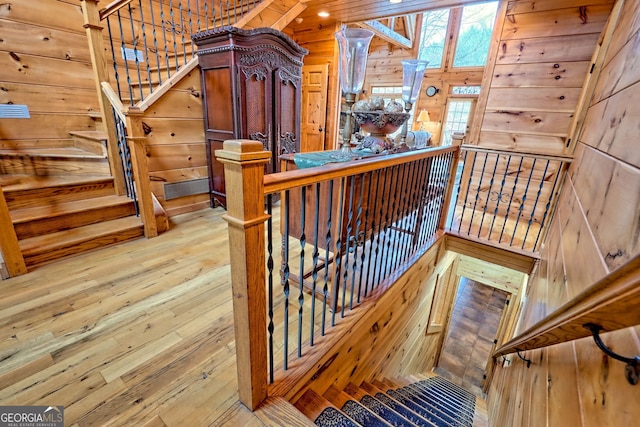 stairway featuring hardwood / wood-style floors and wood walls