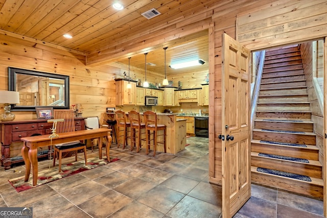 dining space with wood ceiling and wood walls