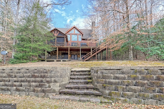 rear view of house featuring a wooden deck